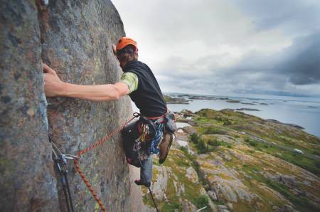 Henningsvær der bak: Simon Svendsen rett ut fra standplass på Gamle Rev (6, 2 tl.), Gandalfveggen. Foto: Jonas Dahlstrup